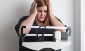 A woman worried about her increasing weight. She needs to find ways on how to prevent obesity.